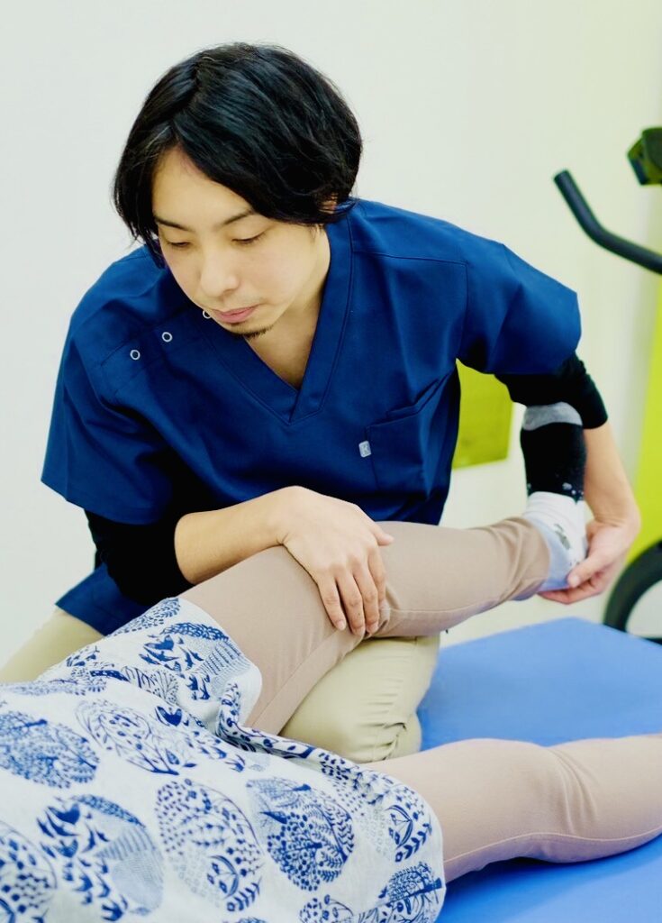 患者の脚を施術する整体師